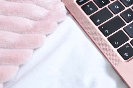 close up of pink laptop on white linen in bedroom,freelance work conceptの写真素材