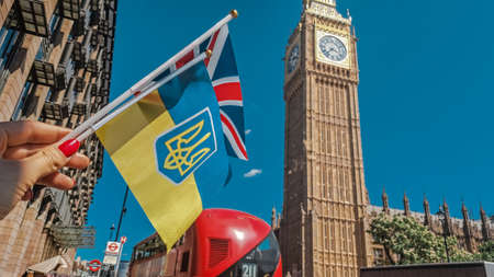 Close up of national flag in hand on London city background . High quality photoの写真素材