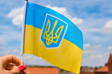 the national yellow and blue flag of Ukraine with trident on blue sky background.の写真素材