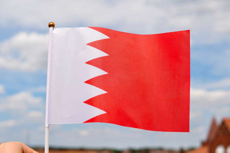 close up of national flag of bahrain on blue sky background ,red and white colors .の写真素材
