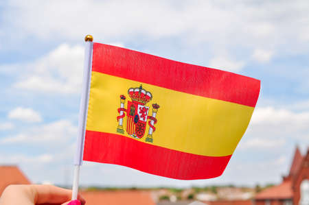 close up of National Spanish flag yellow and red colors,hand holding flag.の写真素材