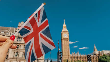 Close up of national flag in hand on London city background . High quality photoの写真素材