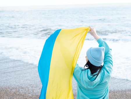 brunnete woman wearing in blue hoodie and blue hat with national flag of Ukraine,patriotic conceptの写真素材