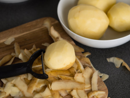 raw potatoes with peeled skin on the wooden desk on the table. High quality photoの写真素材