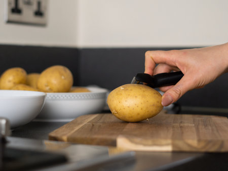 raw potatoes with peeled skin on the wooden desk on the table. High quality photo