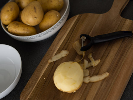 raw potatoes with peeled skin on the wooden desk on the table. High quality photoの写真素材