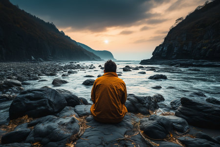 man sitting alone on the ocean shore.の素材