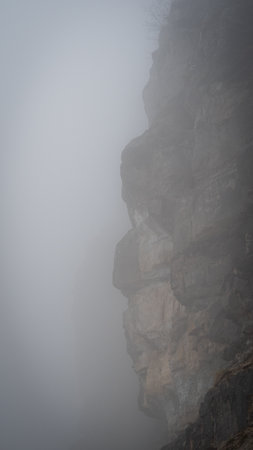 Fog envelops majestic mountain peaks, creating a mystical and serene landscapeの写真素材