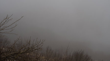 Fog envelops majestic mountain peaks, creating a mystical and serene landscapeの写真素材