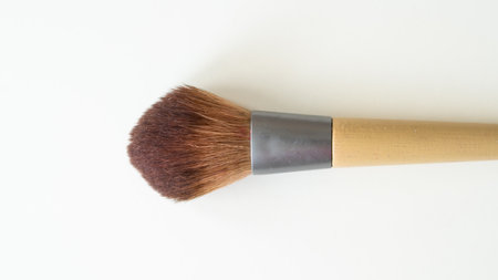 Wooden organic makeup brushes on white backdrop. Eco-friendly, sustainable beauty tools.の写真素材