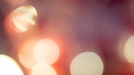 Golden and red bokeh lights create a soft, dreamy background, perfect for a warm, festive atmosphereの写真素材