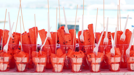 Juicy watermelon pieces in plastic cups, perfect refreshment for a hot day