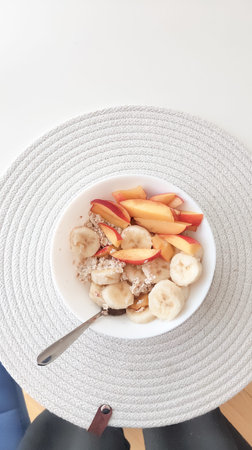 a bowl of oat meal and cup of coffee with milk on the white table in the morning,vegan breakfast