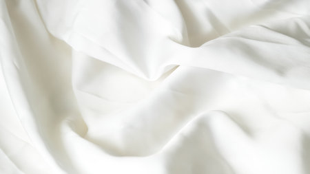 Crumpled white silk fabric background with soft folds and delicate textureの写真素材