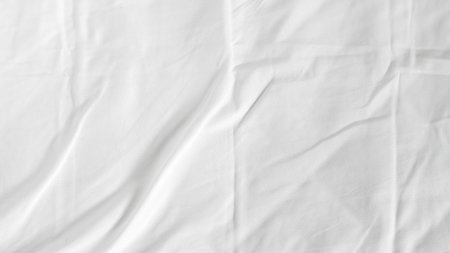 White bedsheets with fluffy blanket on simple background, soft texture and comfort.