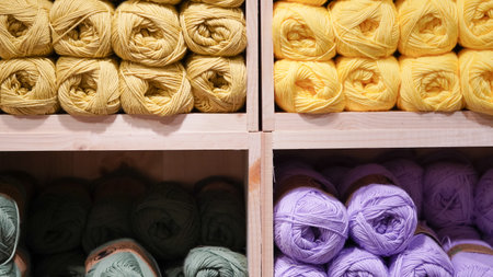 Colorful yarn threads displayed on a shop window, inviting creativity and warmth.の写真素材