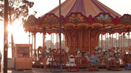 Carousel by the sea at sunset, serene evening ambiance and coastal beautyの写真素材