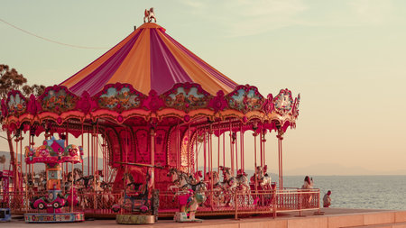 Carousel by the sea at sunset, serene evening ambiance and coastal beautyの写真素材