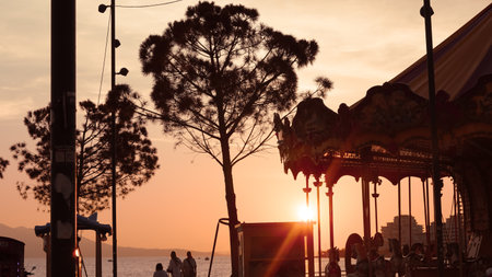 Carousel by the sea at sunset, serene evening ambiance and coastal beautyの写真素材