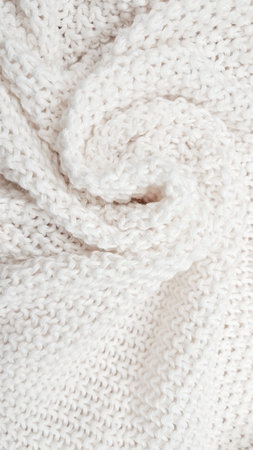 A soft, textured white knitted plaid background with intricate patterns and cozy appeal. High quality photoの写真素材