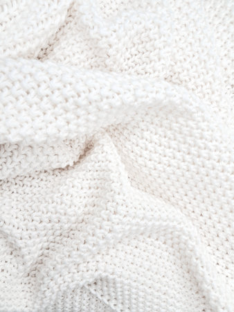 A soft, textured white knitted plaid background with intricate patterns and cozy appeal. High quality photoの写真素材
