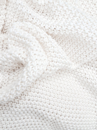 A soft, textured white knitted plaid background with intricate patterns and cozy appeal. High quality photoの写真素材
