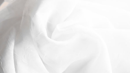 Minimalist white veil background with soft textures and sheer elegant design.の写真素材