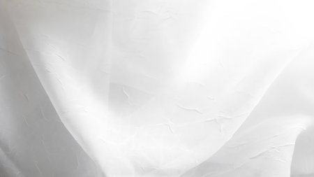 Delicate white tulle veil background with soft folds and elegant texture.の写真素材