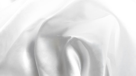 Delicate white tulle veil background with soft folds and elegant texture.の写真素材