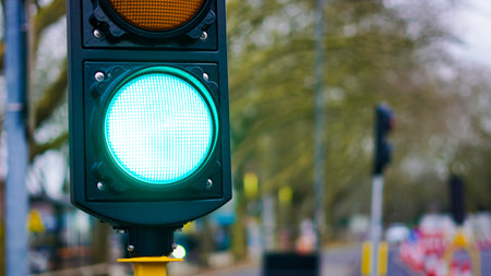 A construction zone with active roadwork and traffic lights regulating the flow