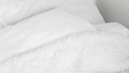 Soft and fluffy white lines on an unmade bed, highlighting minimalist designの写真素材