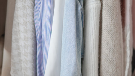 Organizing fresh spring wardrobe with vibrant and pastel clothing on racks