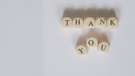 Thank you card with wooden letter cubes on a clean white backgroundの写真素材