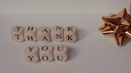Minimalist thank you card with wooden alphabet blocks on whiteの写真素材
