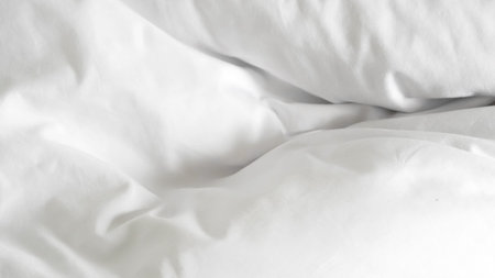 White soft bed linen with a clean duvet, creating a cozy background