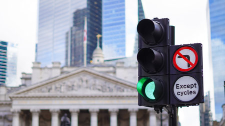 Traffic lights on a European street with pedestrians and tall glass buildings