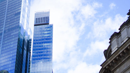 Glass office skyscraper with blue reflections dominating the city sky line