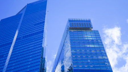 Contemporary high rise building with blue glass reflecting city surroundings