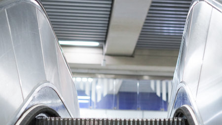 Metallic escalator in a subway station, focus on moving steps and lines