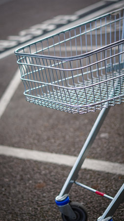 A shopping cart left outside a grocery store near the parking areaの写真素材