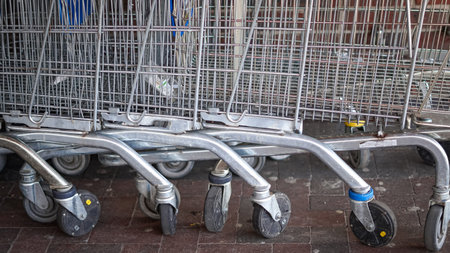 A grocery cart loaded with food items placed near a supermarket entrance