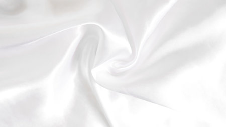 Smooth white silk fabric with soft folds and gentle light reflectionsの写真素材