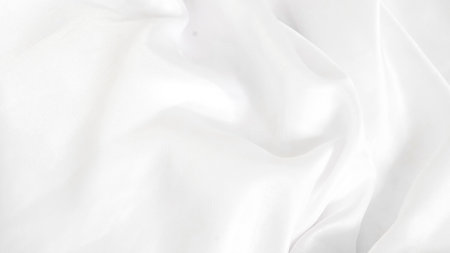 Shiny white silk fabric reflecting soft light, creating a rich textureの写真素材