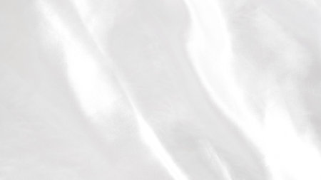 Smooth white silk fabric with soft folds and gentle light reflectionsの写真素材