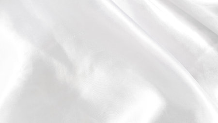 Smooth white silk fabric with soft folds and gentle light reflectionsの写真素材