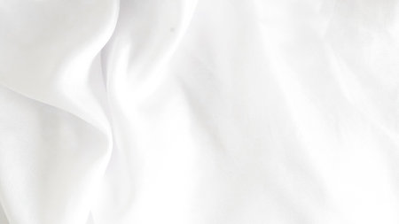 Shiny white silk fabric reflecting soft light, creating a rich textureの写真素材