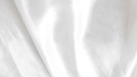 Smooth white silk fabric with soft folds and gentle light reflectionsの写真素材