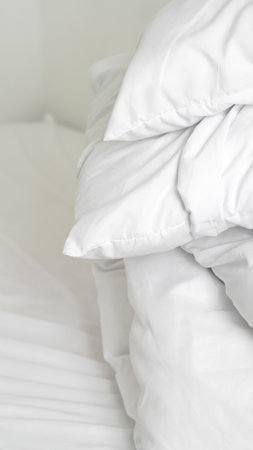 Soft neutral bed linen in minimal hotel room for peaceful relaxing sleep.の写真素材