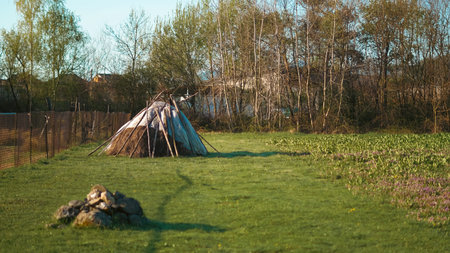 Rural haystack with spring vibes and protective cover in green landscape