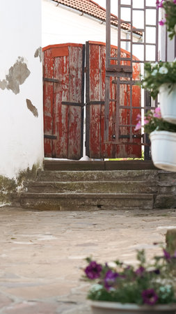 A close-up of an old wooden gate at the entrance to a rustic houseの写真素材